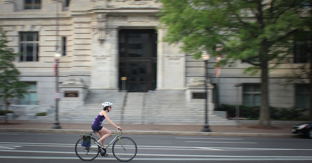 A bicyclist rides in front of the Wilson Building
