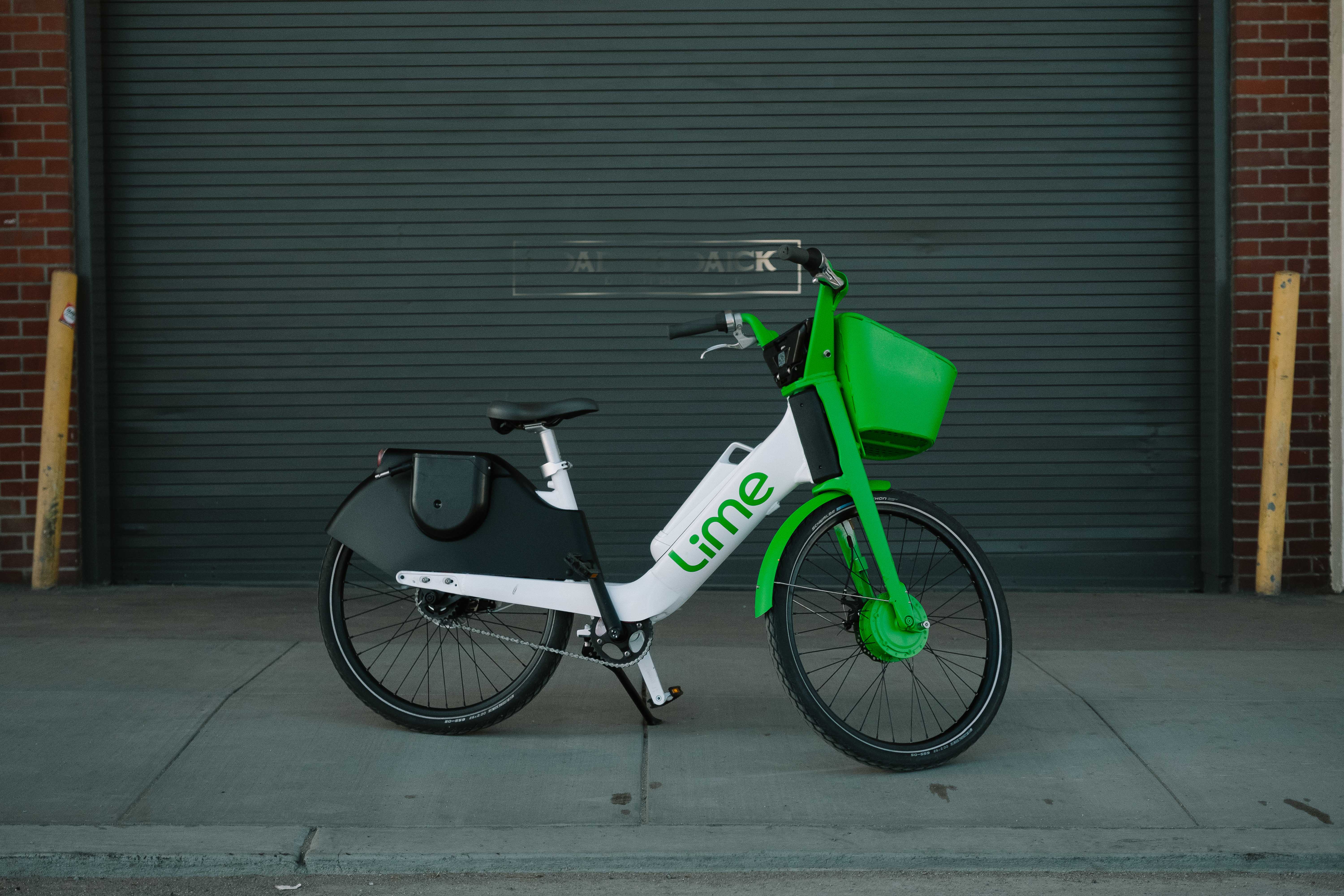 Stock photo of a Lime Ebike parked on a very clean sidewalk