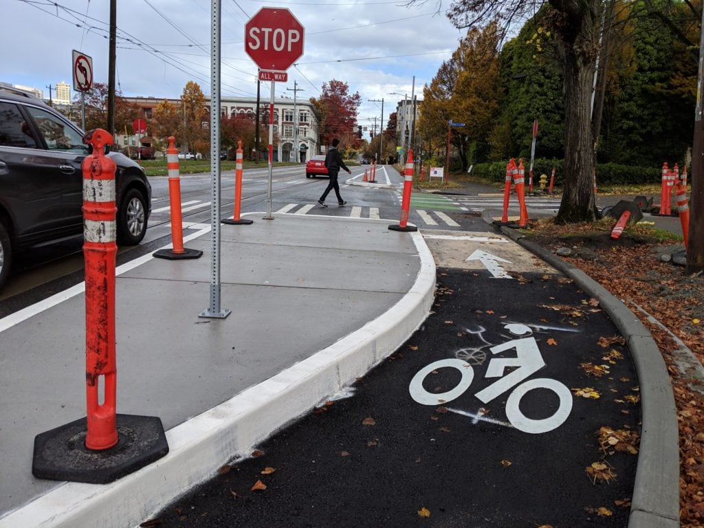 A protected bike lane ending in a stop sign intersection