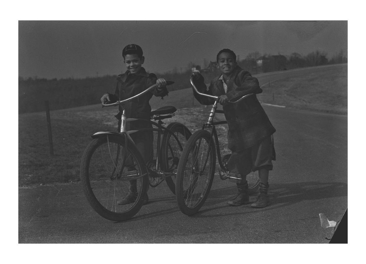 Jack and Earl smile for the camera, while holding onto their bikes.