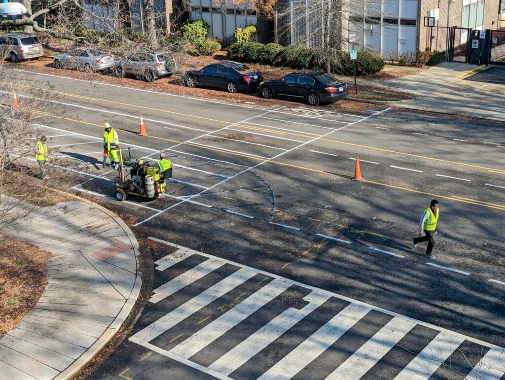 workers painting out new bike lane markings on 4th St SW