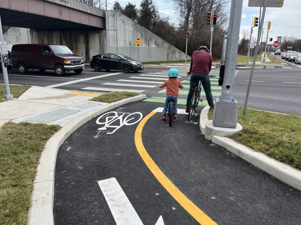 A small child and an adult in the Trolley Trail Extension in Hyattsville, MD.